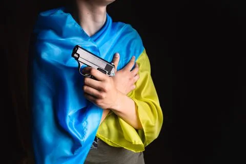 A hand with a weapon on the background of the Ukrainian flag. Bloody hand. Stock Photos