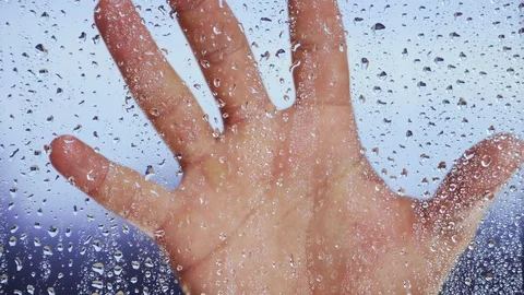Hand on wet window after a rain. Close-up. The theme of depression and suicide Stock Footage 122451497
