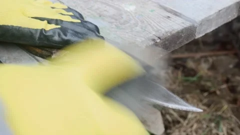 A hand with a whetstone sharpens an old knife, on the table, close-up Vídeos de archivo 228709032
