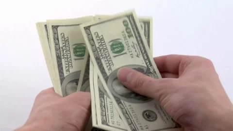 Hand on white background holds bundle of one hundred dollar bills, American Stock-Footage 336264369