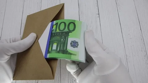 Hand in a white glove counts a bundle of 100 euro banknotes in a brown envelope Stock Footage 145581675