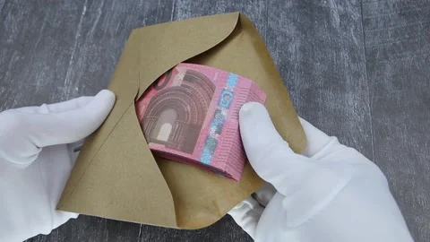 A hand in a white glove counts a bundle of 10 euro banknotes in a brown envelope Vídeo Stock 145630641