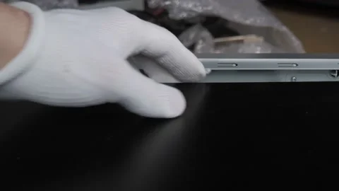 Hand in a white glove, with difficulty puts the side cover on the PC case. Stock Footage 131094924