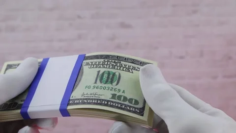 Hand in a white glove holds a stack of 100 dollar paper bills, Close-up, FullHD Vídeo Stock 141429795