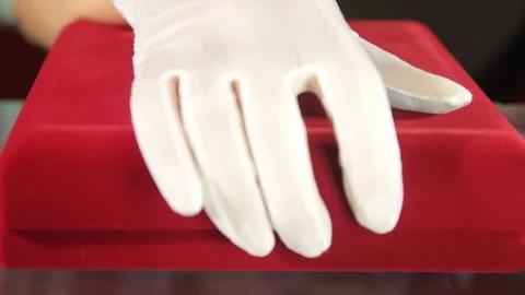 Hand in white glove opens red velvet jewelry box with silver pendant with Stock Footage 116535873