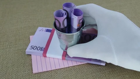 Hand in white glove picks up a small bucket with rolled 500 euro banknotes Vídeo Stock 145450127