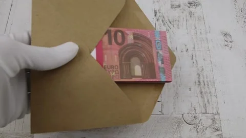 Hand in a white glove puts an envelope with a pack of 10 euro bills on a table Vídeos de archivo 145581636