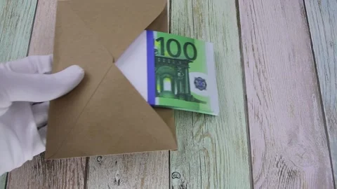 Hand in a white glove puts an envelope with a pack of 100 euro bills on a table Vídeo Stock 146639084