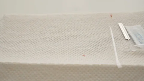 A hand in a white glove puts an rapid coronavirus test on a napkin. The test Stock Footage 128767390