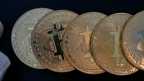 Hand in white gloves spread out gold bitcoins Video stock 98264362