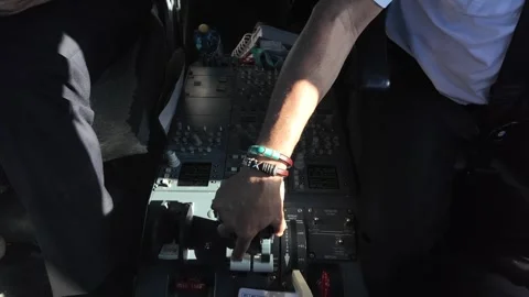 Hand of a white pilot inside a cockpit handling the engine thrust levers of a 動画素材 295768465