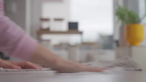 Hand wipes kitchen counter with towel nearby in softly blurred home kitchen Stock Footage 337957640