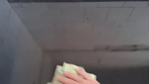 Hand wiping black glossy surface clean in motion video footage Stock Footage 339301854