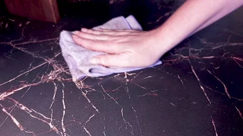 Hand wiping dark marble countertop with cleaning cloth, kitchen cleaning  Stock Footage 337452666