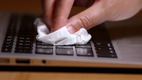 Hand wiping laptop computer keyboard surface Stock Footage 137499026