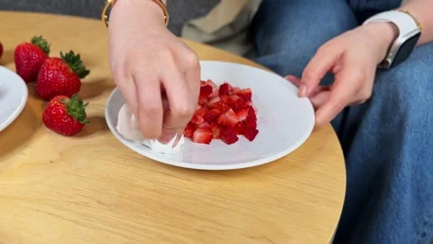 Hand Wiping Plate Edge Next to Diced Strawberries for Acai Bowl Prep | Clean Stock Footage 320606412