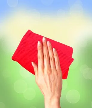 Hand wiping surface with red rag over bright window Stock Photos