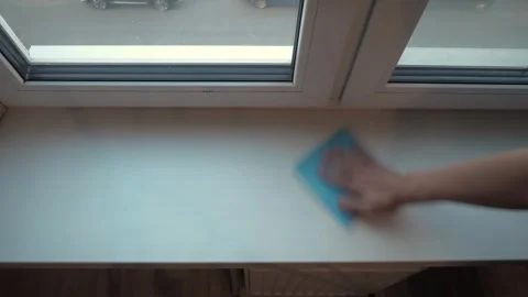 Hand wiping white windowsill with blue cloth Stock Footage 340016482