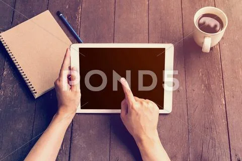 Hand woman holding tablet workink on wood table in coffee shop with vintage f Stock Photos