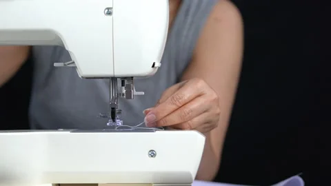 Hand of woman taking the thread out of the sewing machine with black background. Stock Footage 132084965