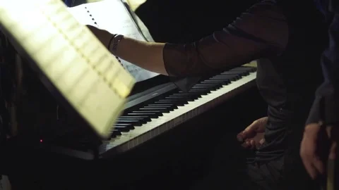 Hand of a woman turning musical sheet and preparing to play piano in slow motion Stock Footage