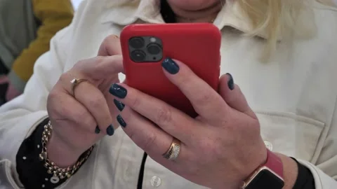 Hand of a woman using a mobile phone reads a phone message and browses the news Stock Footage 212438053
