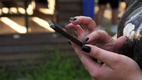Hand of a woman using a mobile phone reads a phone message and browses the news Stock Footage 334723283
