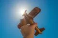 The hand with a wood plane on the background of the bright sun Photo