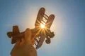 The hand with a wood plane on the background of the bright sun Photo