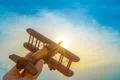 The hand with a wooden airplane on the background of the sunset Photo