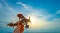 The hand with a wooden airplane on the background of the sunset Photo