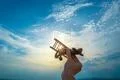 The hand with a wooden airplane on the blue sky background Photo