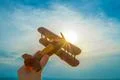 The hand with a wooden plane on the background of the sunrise Photo