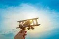 The hand with a wooden plane on the background of the sunset Photo