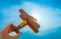 The hand with a wooden plane on the background of the sunset Photo