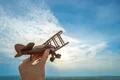 The hand with a wooden plane on the blue sky background Photo