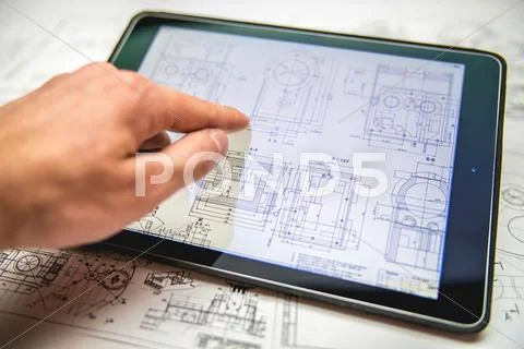 The hand work with tablet (ipod) by blueprints engineering project background Stock Photos