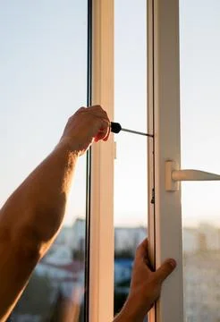 Hand of worker adjusting plastic window. Stock Photos