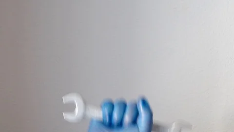 Hand of a worker with blue gloves and a tool raising his arm Stock Footage 128978877