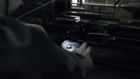 The hand of the worker controls the tension of the thread unwinding the bobbin Stock Footage 154697793