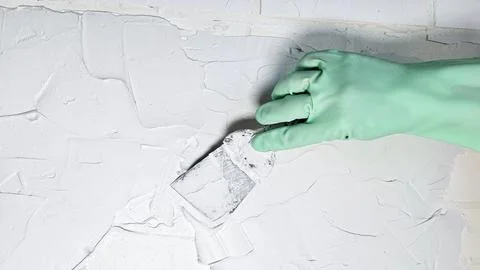 The hand of a worker holding a spatula for applying putty to the walls Stock Photos