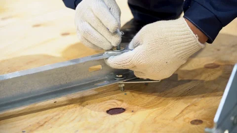 Hand of worker mount billet consisting, attaches plate to metal rack close up. Stock Footage 126356303