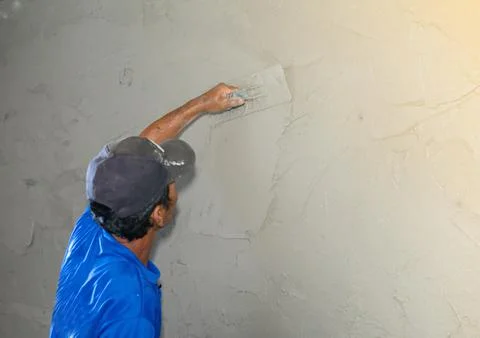Hand of worker plastering cement wall at construction site . Stock Photos