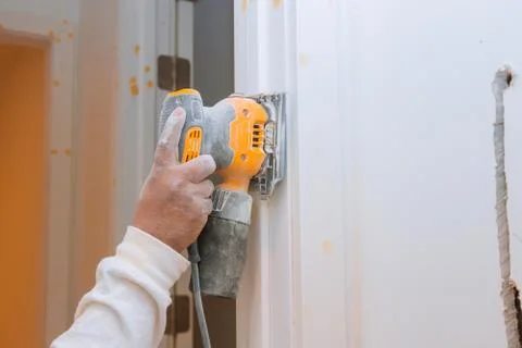 Hand of worker sanding and preparing the wood trim molding for door framing h Foto stock