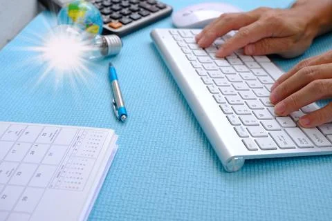 Hand working computer on table top view on working space with office equipmen Stock Photos