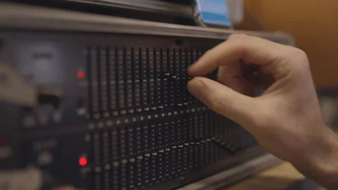 Hand works on graph equalizer display in the studio. Waveform adjustment Stock Footage 147156971