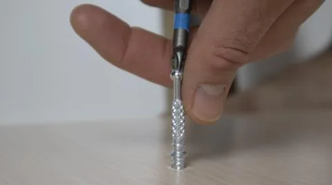 Hand wraps a screw. Stock Photos