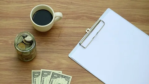 Hand write word "save" on clipboard with money and coffee, money saving concept Stock Footage 80907679