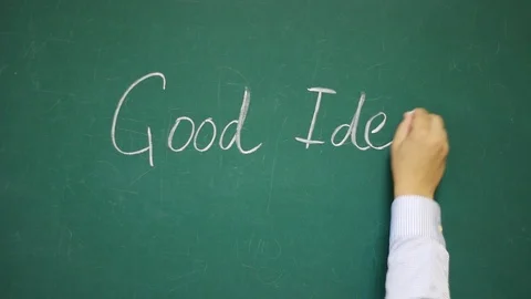 Hand writes GOOD IDEA on a chalkboard Video stock 123674626