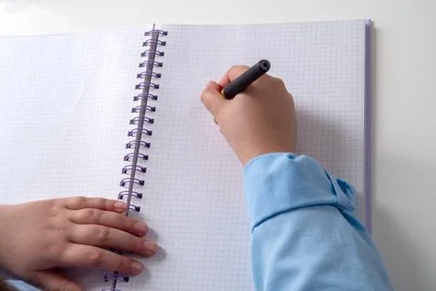 Hand writes on graph paper with a black marker Foto stock